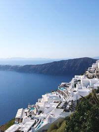 High angle view of townscape by sea against clear sky