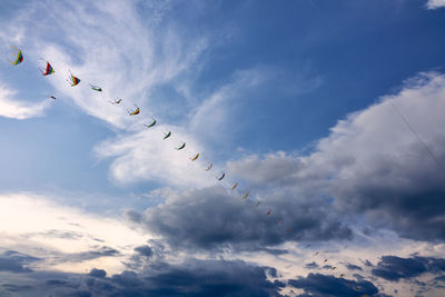 Low angle view of birds flying against sky