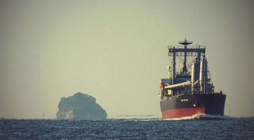 Ship sailing at sea against sky