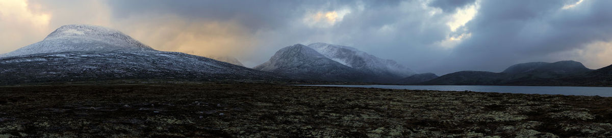 Scenic view of mountains against cloudy sky