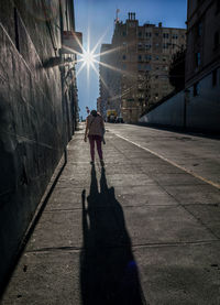 Rear view of man walking on street in city