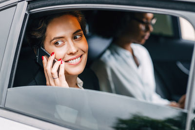 Portrait of a smiling mid adult woman sitting in car