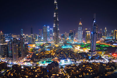 Illuminated cityscape against sky at night