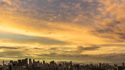 View of cityscape against cloudy sky during sunset