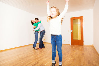 Portrait of happy girl standing on hardwood floor