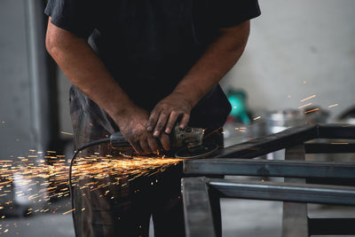 Midsection of man welding metal