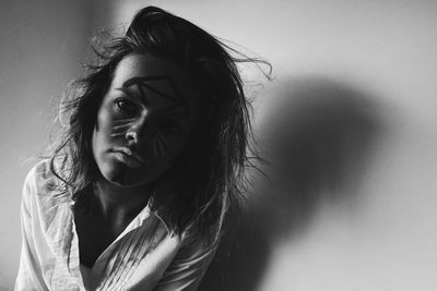 Close-up of young woman with face paint by wall