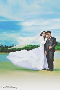 Full length of mother and daughter standing on landscape against sky