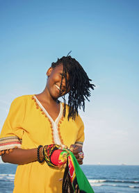 Woman standing on beach against sky