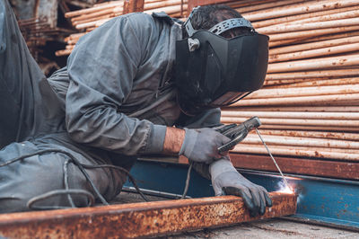 Low angle view of man working on wood