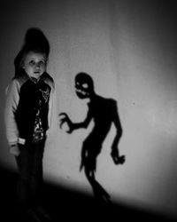 Portrait of smiling girl standing against wall during halloween