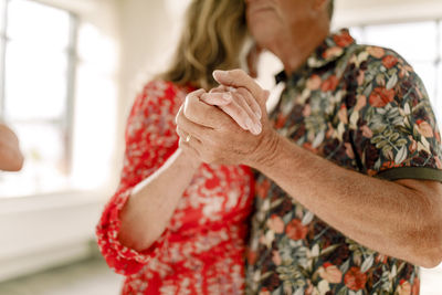 Senior couple holding hands while dancing together in class