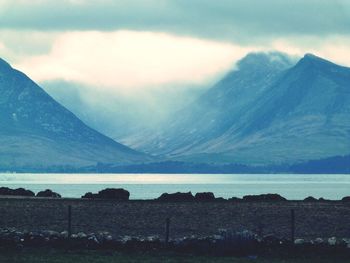 Scenic view of mountains against cloudy sky