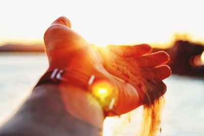 Close-up of hand against sea