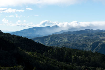 Scenic view of mountains against cloudy sky