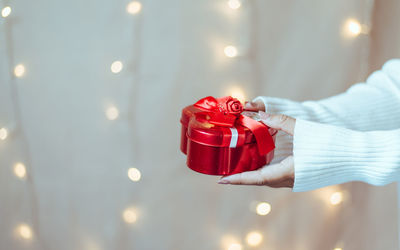 Midsection of woman holding christmas lights