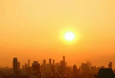 Modern buildings against sky during sunset