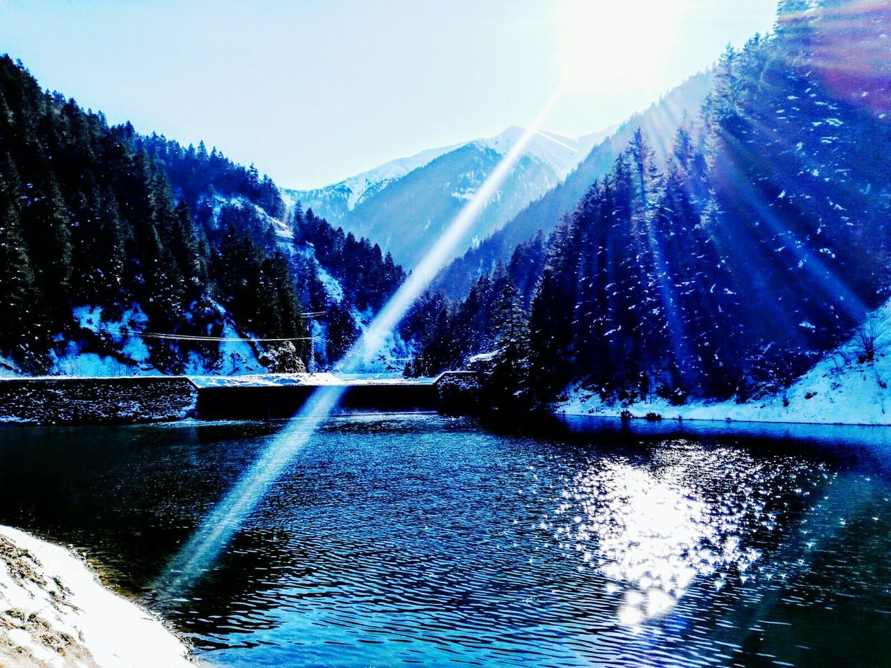 water, waterfront, sunbeam, sunlight, sun, reflection, beauty in nature, scenics, lens flare, mountain, tranquility, tree, tranquil scene, nature, lake, river, blue, clear sky, rippled, sunny