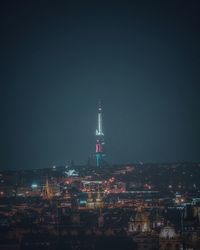 Illuminated buildings in city against sky at night