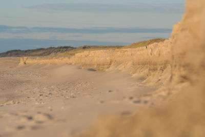 Scenic view of sand dunes against sky