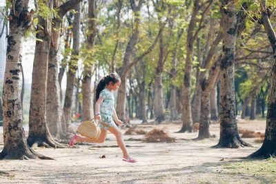 Young woman walking along trees