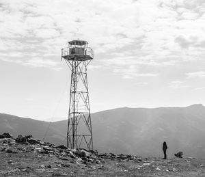 Man standing on mountain by land against sky