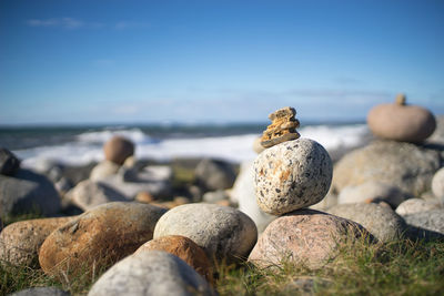 Close-up of pebbles on beach against sky