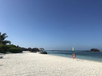 Scenic view of beach against clear blue sky