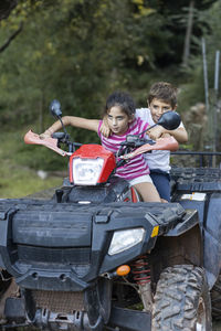 Two little kids riding a quad