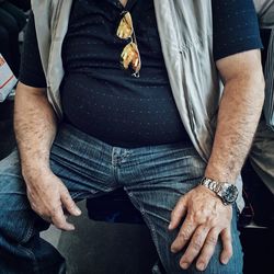 Midsection of man sitting in train