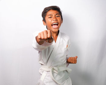 A child is demonstrating a martial arts punch