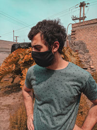 Portrait of young man wearing sunglasses standing against sky