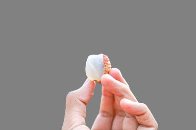 Hand holding ice cream cone against black background
