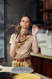 Portrait of young woman having food at home