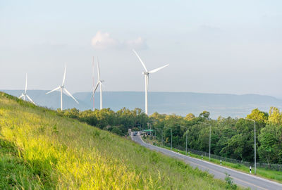 Wind turbines on field against sky