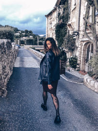 Portrait of woman walking on road in city