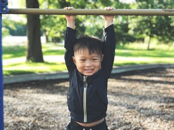 Portrait of smiling boy playing at jungle gym