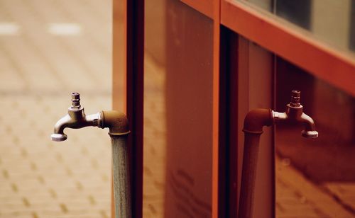 Close-up of faucet against wall