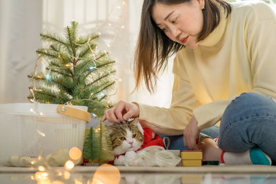 Portrait of young woman holding cat at home