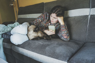 Woman with smart phone looking at cat