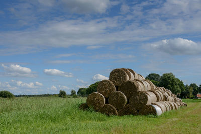 Hay bales on field against sky