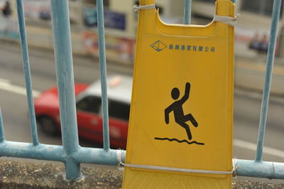 Close-up of sign board on railing