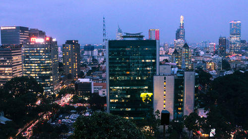 Illuminated buildings in city against sky at night