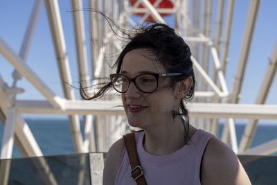 Portrait of young woman looking away outdoors on ferris wheel