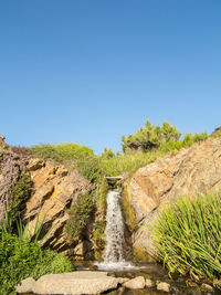 Scenic view of waterfall against clear sky