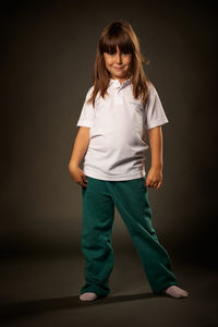 Portrait of girl standing against gray background