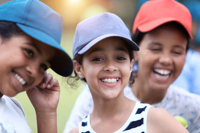 Close-up of smiling girls wearing caps