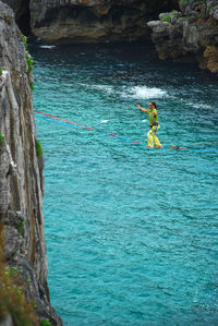 Man standing on rock by sea