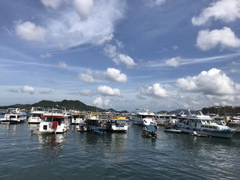 Boats moored at harbor against sky