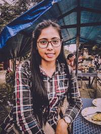 Portrait of smiling young woman standing outdoors